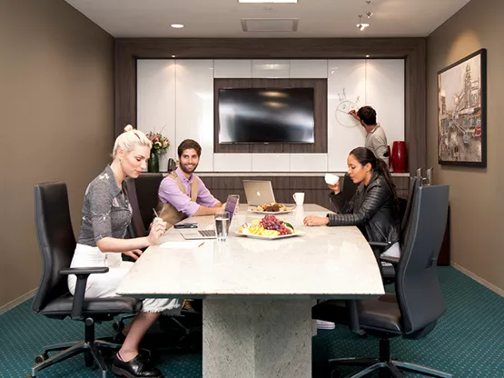 Clients collaborating in a Servcorp meeting room at 10 Avenue Kléber, enjoying a premium setting .