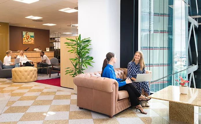 Clients working in 5-star coworking space with a stunning view and a vibrant reception.