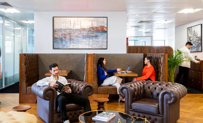 Clients working and networking at Canary Wharf with 5-star fitout, a vibrant reception, and collaborative booths.